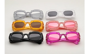 Vue à plat de lunettes de soleil aux bords pétales en six couleurs sur fond gris