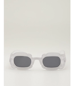 Détail de lunettes de soleil ondulées avec monture mate translucide et verres foncés