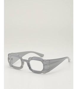 Détail de lunettes de soleil grises avec monture ondulée et design fleur unique