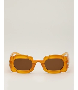 Gros plan de lunettes de soleil ambrées avec bordure ondulée et verres marrons