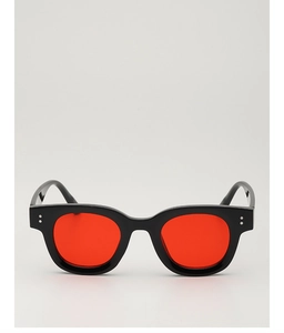 Detailansicht der schwarzen quadratischen Sonnenbrille mit roten Gläsern und Nieten