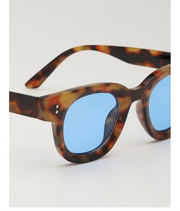 Details von Sonnenbrillen in Schildpatt-Optik mit blauen Gläsern und Silbernieten