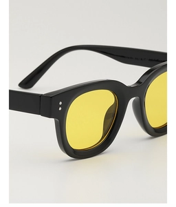 Details von quadratischer Vintage-Sonnenbrille mit gelben Gläsern und Silbernieten