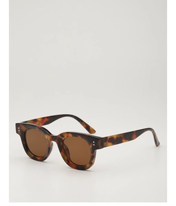 Detailaufnahme einer Vintage-Sonnenbrille in Schildpatt-Optik mit silbernen Nieten