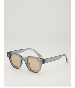 Details einer quadratischen, transparent-grauen Sonnenbrille mit braunen Gläsern