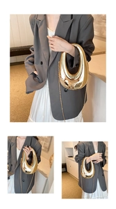 Detail of artistic gold mirror acrylic clutch with irregular hollow design and chain