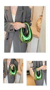 Detail of emerald green acrylic box bag with gold chain strap and hollow egg-shaped handle
