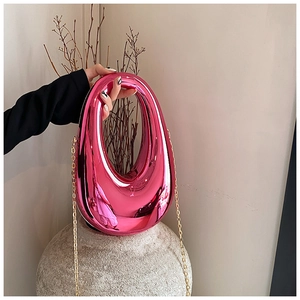 Detailed view of pink metallic egg-shaped acrylic clutch bag with gold chain strap