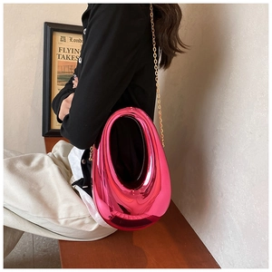 Detail of rose pink acrylic box bag with metallic finish and gold chain strap