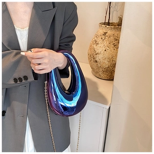 Chic holographic purple acrylic box bag with gold chain strap on a model shoulder