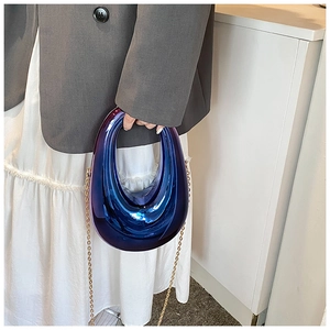 Detail of blue gradient metallic acrylic box bag with golden chain and oval handle