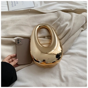 Detail of gold mirror teardrop clutch bag with hollow handle and metal chain strap