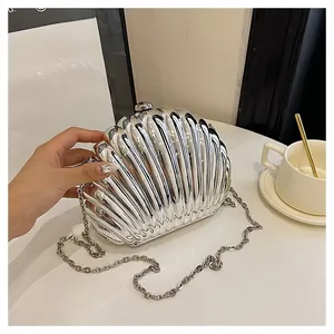 Detail of silver shell-shaped clutch bag with metallic finish and metal chain strap