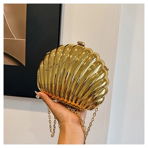 Close-up of golden shell evening clutch with metallic ridges and chain strap