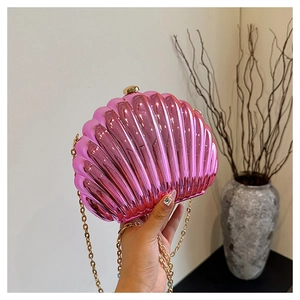 Detail of rose pink shell-shaped evening bag with metallic texture and gold chain