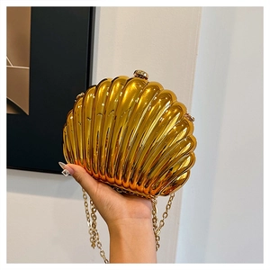 Detailed view of the gold shell-shaped evening clutch with metallic pleated texture