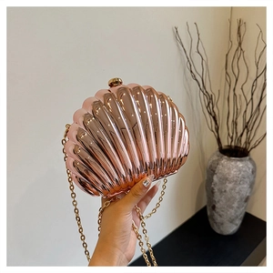 Close-up of a rose gold shell-shaped clutch bag with elegant metallic chain strap