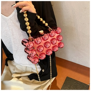 Detail of pink acrylic egg-shaped handbag featuring 3D bubble texture and gold bead handle