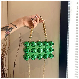 Detail of emerald green acrylic bag with 3D bubble texture and gold beaded handle