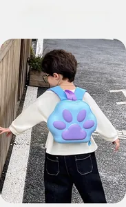 Rear view of child wearing a blue toddler backpack with a 3D purple paw pattern detail