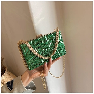 Dettaglio pochette da sera verde lime metallizzato con trama stropicciata e catena d'oro