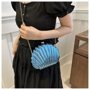 Detailed view of candy color shell clutch with aurora blue finish and golden chain
