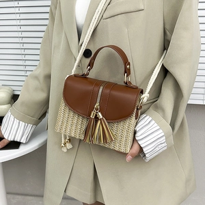 Détail d'un sac bandoulière en paille avec gland en cuir et bandoulière en coton