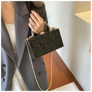 Dettaglio della pochette in acrilico nero con trama ghiaccio e telaio in metallo oro