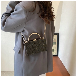 Elegante pochette da sera nera con trama craquelé e manici circolari in metallo oro