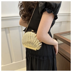 Elegant gold shell-shaped clutch bag with metallic texture and thin chain strap for women