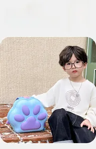 Toddler backpack with cute blue paw design and purple details worn by boy in park