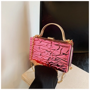 Dettaglio della borsa da sera rosa metallizzata con trama stropicciata e manico oro