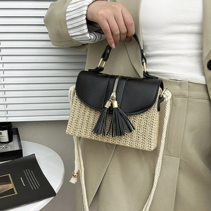 Détail du sac en paille tressée avec rabat en cuir noir et fermoir métallique doré