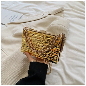 Dettaglio pochette dorata in acrilico con trama effetto ghiaccio e tracolla a catena