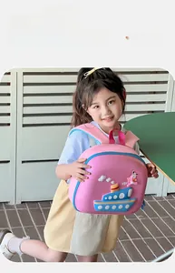 Side view of a 3D ship relief toddler backpack worn by a girl on a sunny terrace