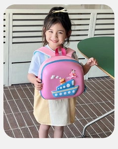 Detail view of pink kids backpack featuring 3D ship and airplane on a little girl