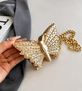 Primer plano detallado de un bolso de noche con forma de mariposa y pedrería brillante
