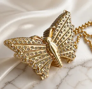 Primer plano detallado del mini bolso mariposa dorado con diamantes de imitación y cadena