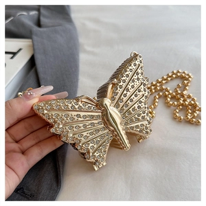 Detalle del bolso de mano mariposa dorado con diamantes y cadena de cuentas
