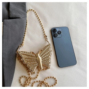 Detalle de mini bolso de mariposa dorada con brillantes incrustaciones de strass