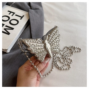 Detalle de bolso de fiesta de mariposa plateada con diamantes de imitación y cadena