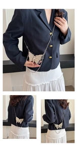Detalle del mini bolso de mariposa metálico con cadena de bolas y relieve fino