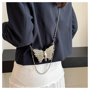 Detalle del mini bolso mariposa plateado con cristales brillantes y cadena metálica