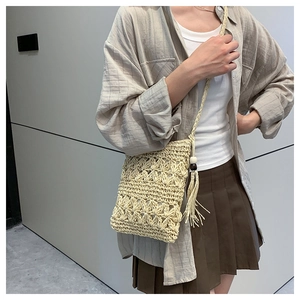 Macro shot of boho straw bag featuring hollow weave patterns and stylish fringe details