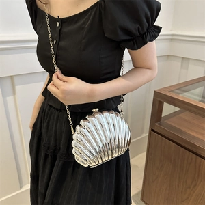 Elegant silver shell clutch bag with metallic texture and gold chain for women