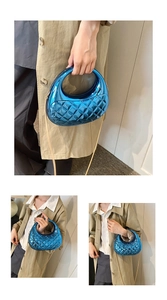 Detail of metallic blue quilted acrylic box bag with gold chain and round handle