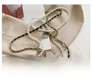 Detail of mini quilted bag strap with white pearls and gold metal leather chain