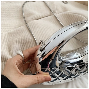 Detail of silver mirror acrylic box bag with quilted diamond pattern and snake chain