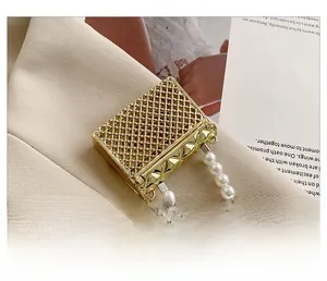 Macro shot of gold metal mesh mini bag featuring elegant pearl chain strap and rivets