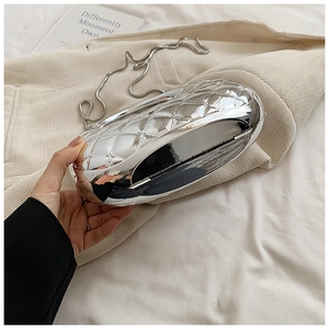 Macro detail of silver rhombic quilted acrylic evening bag with fine metal chain
